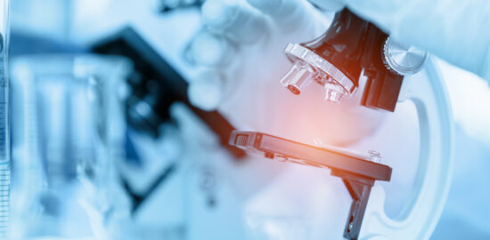 Close Up Scientist using microscope in laboratory room while making medical testing and research